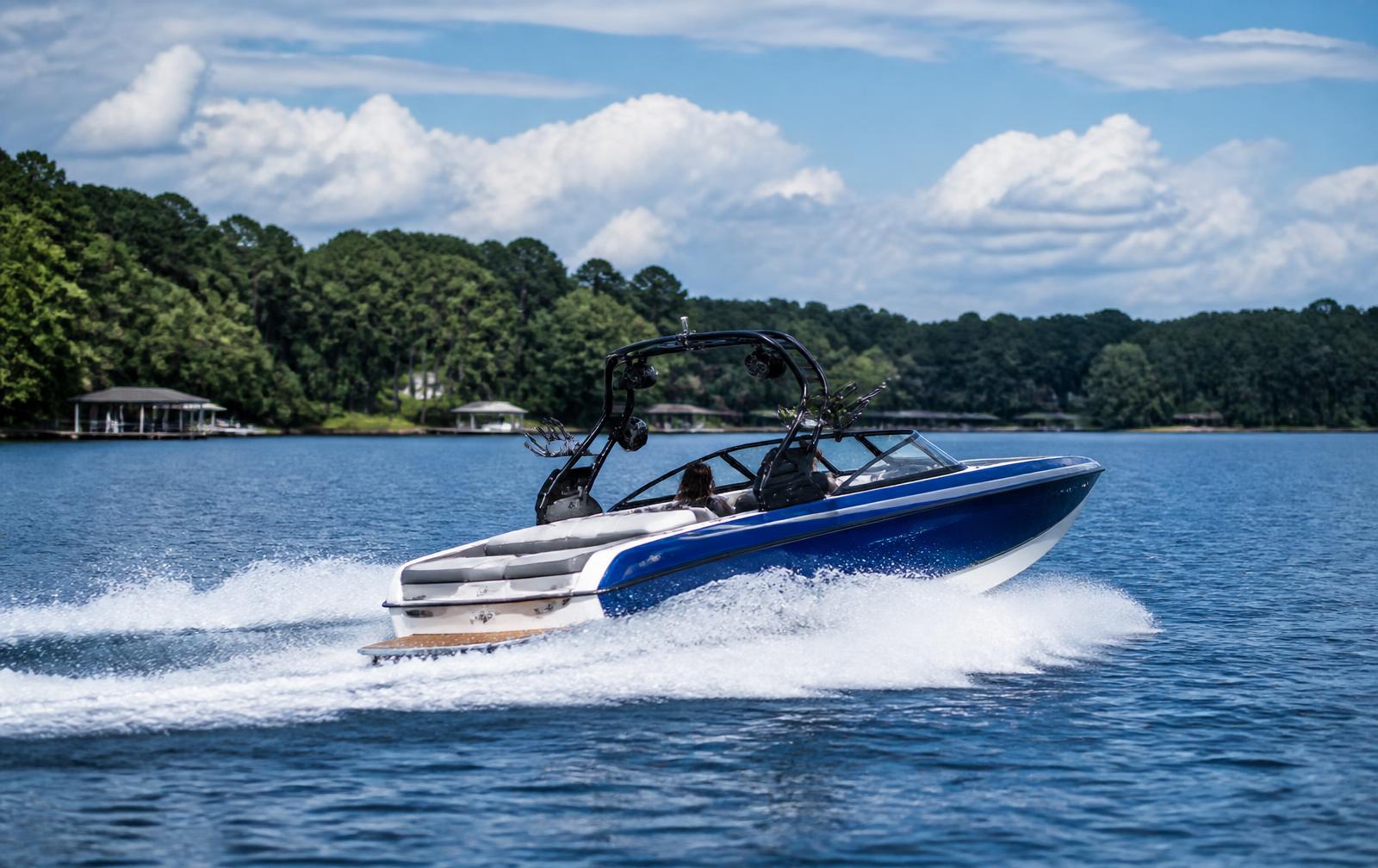 Wakeboard boat running across open water on Lake Wylie on a clear summer day