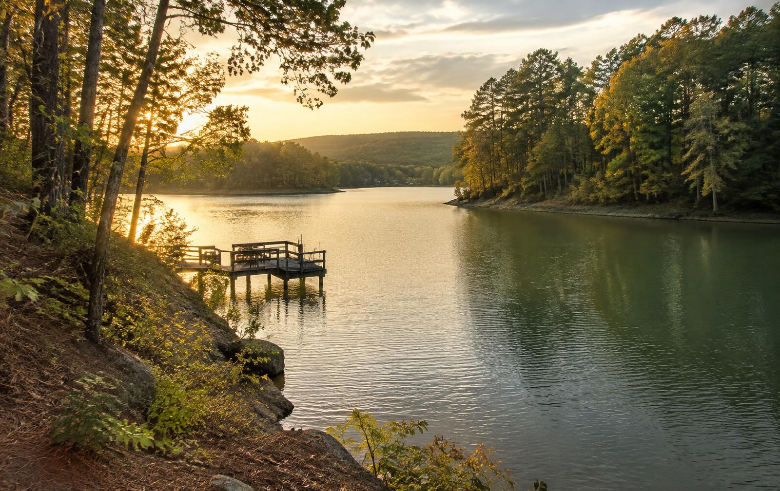 Golden-hour light on a quiet wooded creek arm of Lake Wylie with a small private dock